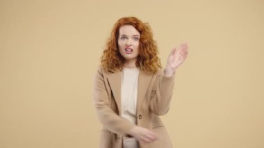 Sinirli 30 'lu yaşlarda öğrenci bir kadın bej arka planda elleri olan bla-bla-bla hareketi gösteriyor. Boş vaatler, ironi, falan filan. Yalancı! Yüksek kalite 4k