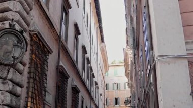 Pastel duvarları ve geleneksel ahşap panjurları olan klasik Roma yerleşim yerleri. Dar Avrupa caddesi. Eski duvarcılık ve günlük Roma yaşamının cazibesi.