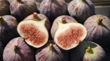 Tahta masadaki çiçekli taze incirler. Ficus carica. Güzel mevsimlik meyveler, vejetaryen yemekleri. Üst Manzara. Dolly kaydırma atışı..