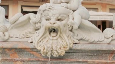 Roma 'da süslü taş çeşme maskesi, çarpıcı heykel yüz, açık ağızdan akan su. Klasik detay antik Roma sanatını, mitolojisini, tarihi şehir mimarisini yansıtır..
