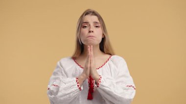 Genç Ukraynalı Kadın Avuçlarıyla İçten Sessizlik İsteğinde Bulunuyor. Umut, Faith. Bej renkli stüdyo geçmişi olan çekici bir bayan. Şans için dua ediyor. Yüksek kalite 4k