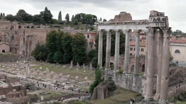 Roma, İtalya - 25 Eylül 2025. Roma Forumu 'nun geniş manzarasında antik kalıntılar, taş sütunlar, tarihi yapılar sergileniyor. Turistler ikonik arkeolojik alanı keşfediyorlar