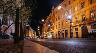 Prag, Çek Cumhuriyeti - 25 Kasım 2025. Narodni Trida Caddesi 'nde Narodni divadlo Tiyatrosu' nun yanında bir gece. Araba ve tramvay ışıkları tarihi cepheler ve sokak lambaları boyunca akar.