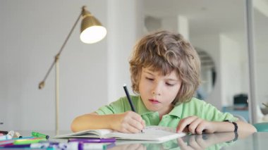 Renkli sanat aletleri kullanarak evde resim çizen sevimli bir çocuk. Çocukluk yaratıcılığı, aile yaşam tarzı, eğitim, evde öğrenme, ebeveynlik, mutluluk ve rahat yaşam kavramları için mükemmel.