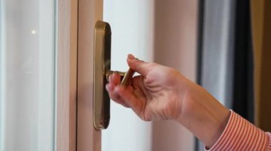 Modern bir evde klasik tarzda yapılmış beyaz bir pencere açan kadın. Yumuşak gün ışığı odaya giriyor, temiz havayı, rahatlığı, yeni bir başlangıcı, ev atmosferini ve günlük yaşam tarzını simgeliyor..