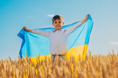Ulusal Buğday Bayrağı Arkasında Mutlu Ukraynalı Vatansever Çocuk. Ukrayna, barış, bağımsızlık, özgürlük, savaşta zafer. Yüksek kalite fotoğraf