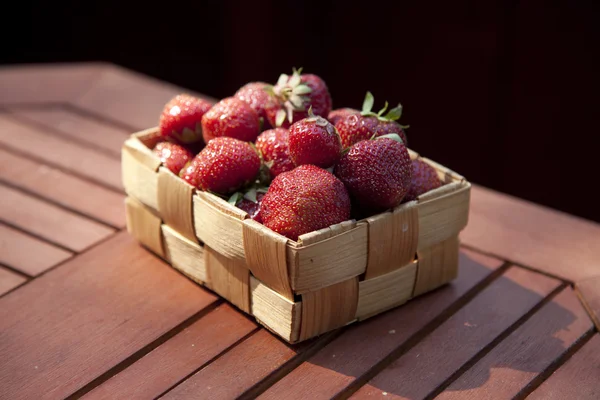 Fresas en una pequeña cesta de madera — Foto de Stock