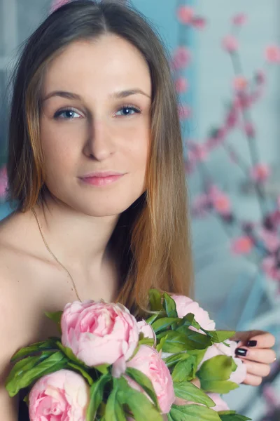 Beautiful close-up portrait of a young woman with peonies — Stock Photo, Image