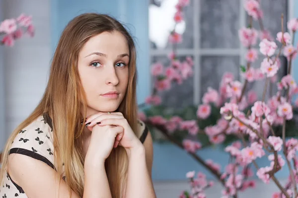 Vacker flicka med långt hår i blommande trädgård — Stockfoto