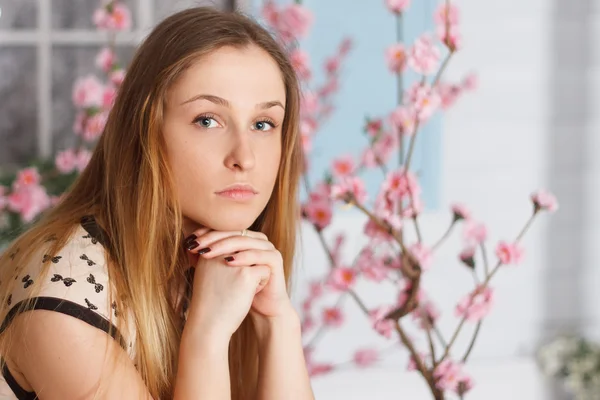 Hermosa chica con el pelo largo en el jardín de flores —  Fotos de Stock