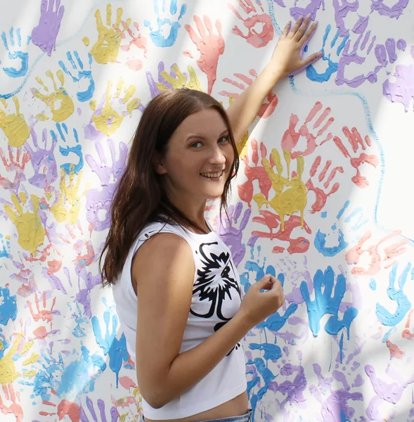 Dziewczyna znaczki śledzenia ręce na ścianie z nadrukami — Zdjęcie stockowe