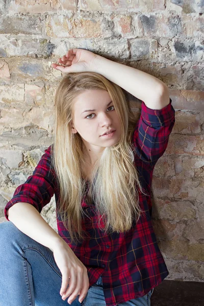 Vista frontal da menina branca atraente sentado no chão de madeira — Fotografia de Stock