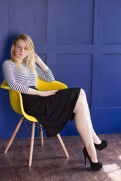 椅子に座っているスカートとベストのブロンドの女の子 — ストック写真