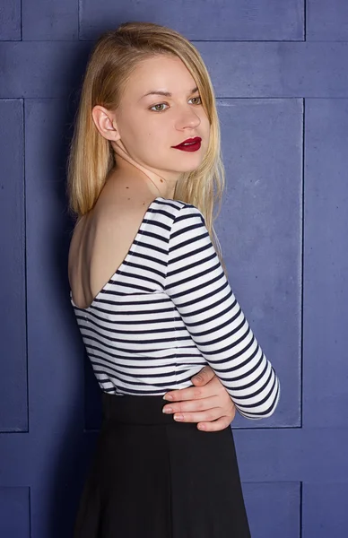 Beautiful blonde in a shirt-vest near wall — Stock Photo, Image