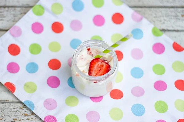 Słoik jogurtu i truskawki z wielobarwne tkaniny — Zdjęcie stockowe