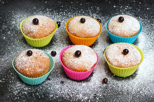 Muffins with black currant in silicone forms sprinkled — Stock Photo, Image