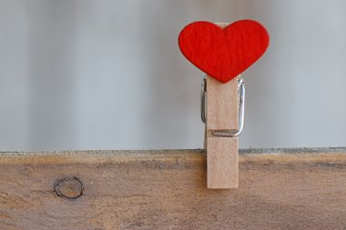 Clothespin ahşap arka plan üzerinde bir kalp şeklinde