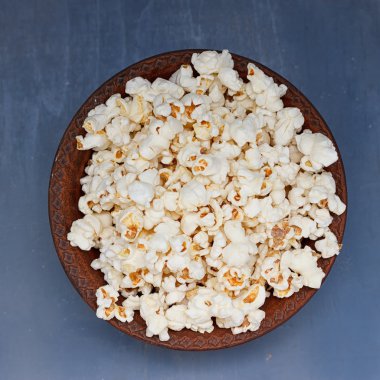 mavi bir arka plan üzerinde patlamış mısır kase