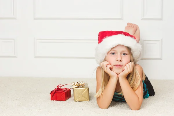 Menina em um boné de Natal mentiras — Fotografia de Stock