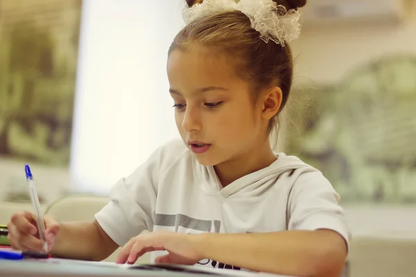 First grader girl writes a pen — Stock Photo, Image