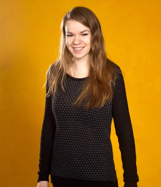 Flicka på en bakgrund av orange vägg — Stockfoto
