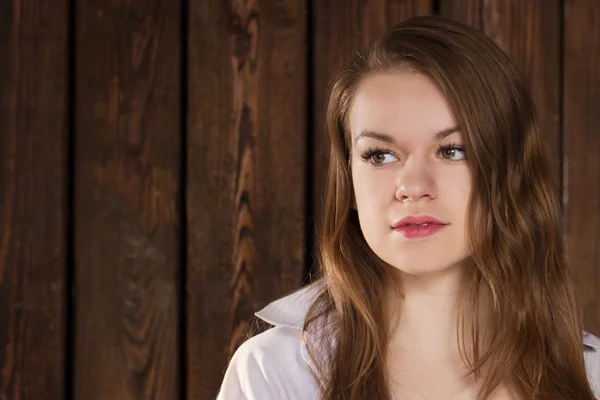 Portrait of a girl on wooden wall — Stock Photo, Image