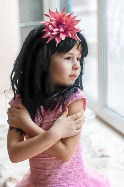 Porträt eines sechsjährigen Mädchens im Fenster — Stockfoto