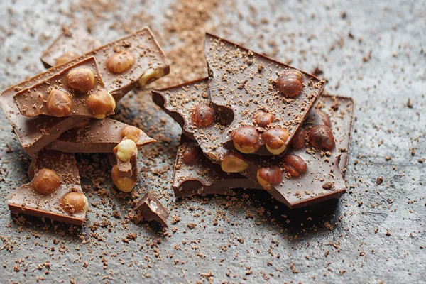 Chocolate com nozes em fundo de madeira — Fotografia de Stock
