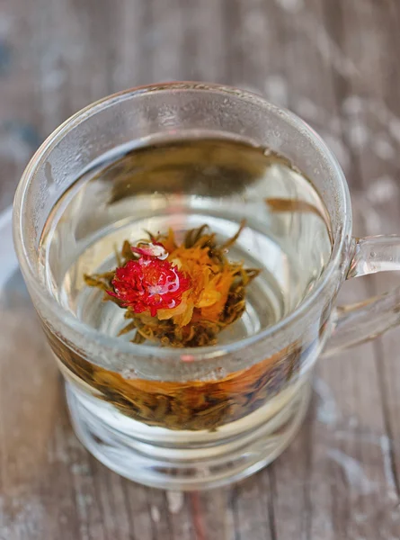 Thé vert exotique avec des fleurs en tasse — Photo