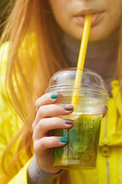 Girl is drinking a large glass of lemonade — Stock Photo, Image