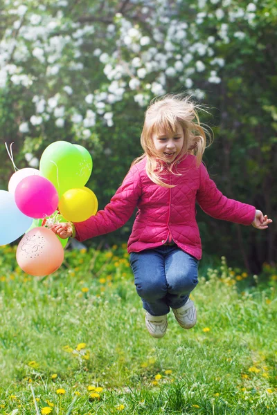 Mała dziewczynka gra z balonów, skoki — Zdjęcie stockowe