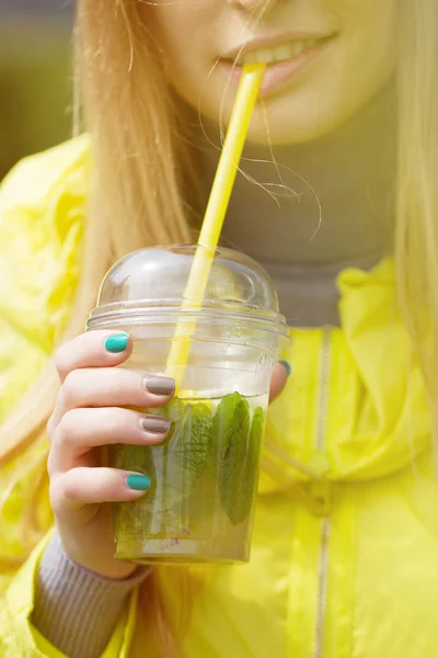 Girl is drinking a large glass of lemonade — Stock Photo, Image