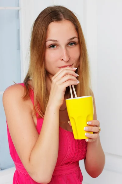 Girl in a pink dress with yellow glass hand at home — Stock Photo, Image