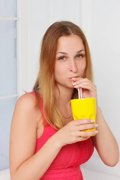 Girl in a pink dress with yellow glass hand at home — Stok fotoğraf