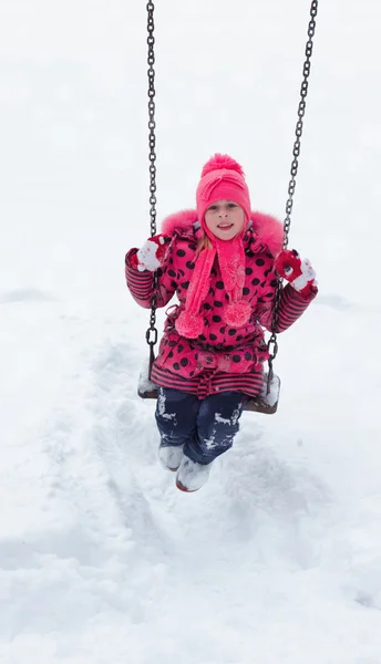 Menina brincando em uma pilha de neve . — Fotografia de Stock