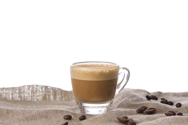 Cappuccino with crema in transparent cup on sacking — Stock Photo, Image