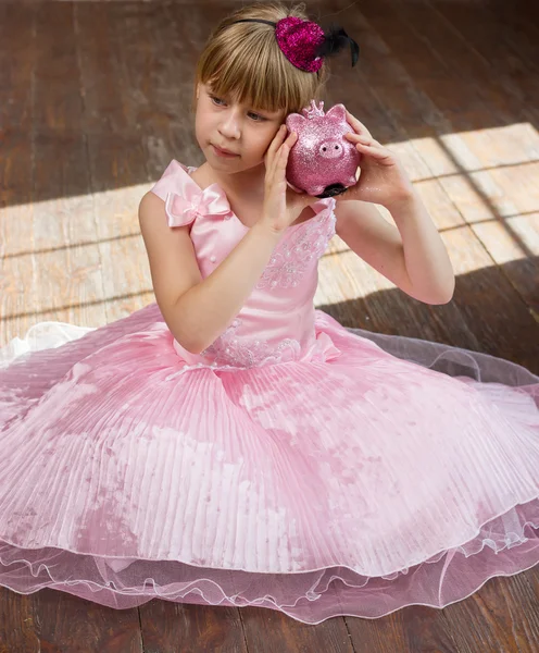 Menina 6 anos de idade em vestido rosa com um banco porquinho colheita quadrada — Fotografia de Stock