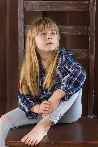 Flicka 6 år gammal sitter på en hög stol — Stockfoto