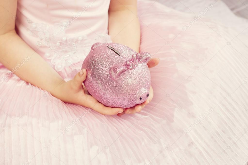 Pink piggy bank in the children's hands