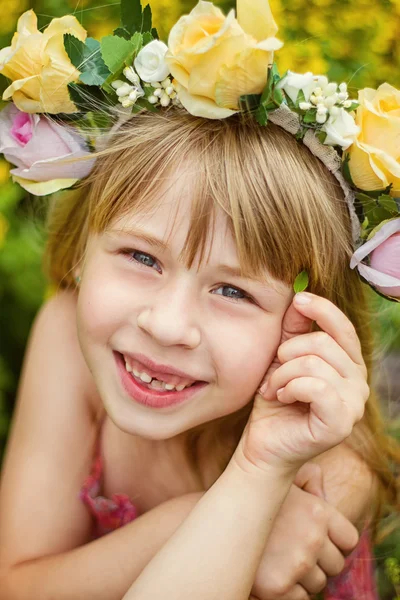 Girl 6 years old in  wreath closeup. Smiles. Baby teeth fall out. — Stock Photo, Image