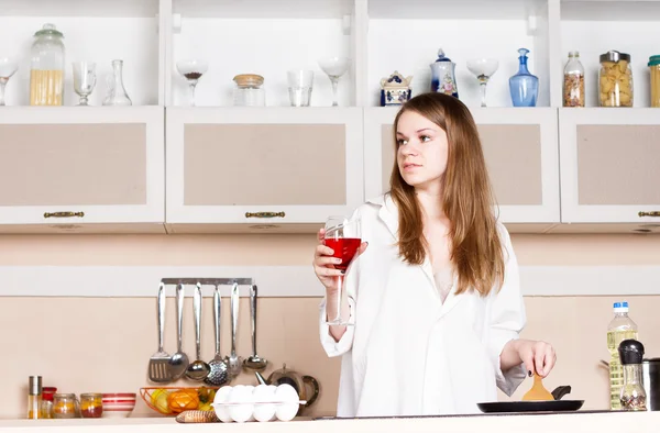 Ragazza in cucina con un bicchiere di vino rosso — Foto Stock