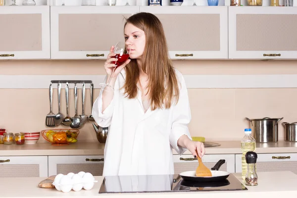 Girl in white men's shirt drinking red wine near the pans — Stock Photo, Image