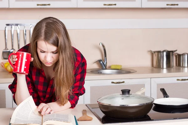 Chica de pelo largo que fluye una camisa de hombre rojo en la cocina con la taza de sus manos —  Fotos de Stock