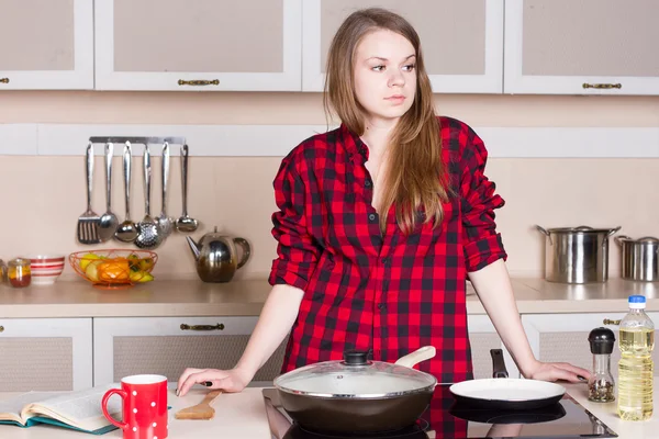 Girl is lost in thought over stove — Stock Photo, Image