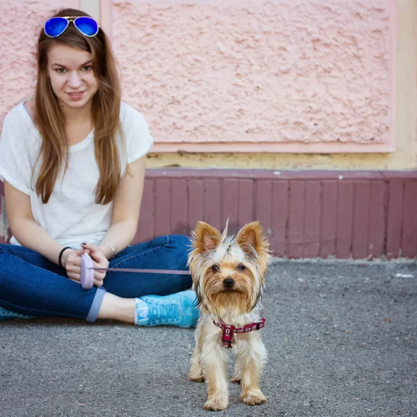 Zemin ve Yorkshire terrier üzerinde oturan güzel spor Bayan — Stok fotoğraf