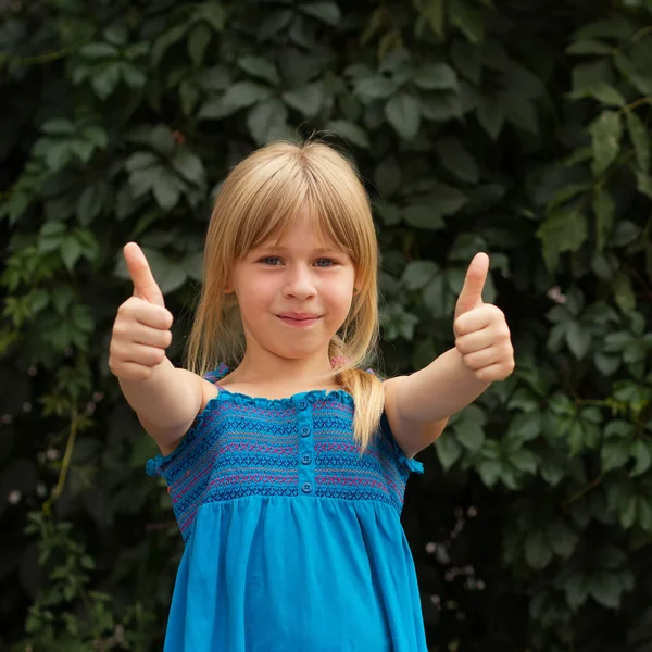 Lachen meisje met daisy duimen opdagen — Stockfoto