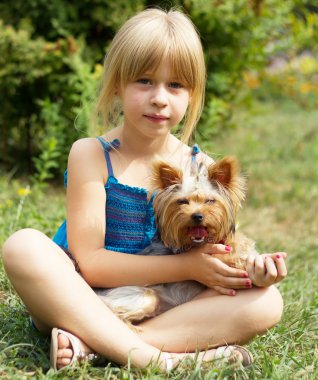 Yorkshire Terrier ile çim üzerinde kız 6 yaşında oturan