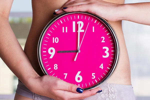 Reloj biológico tictac - relojes rosa en las manos femeninas —  Fotos de Stock