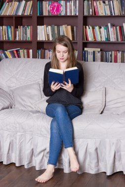 Kadın kütüphanede kitap okuma