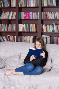 Kadın kütüphanede kitap okuma